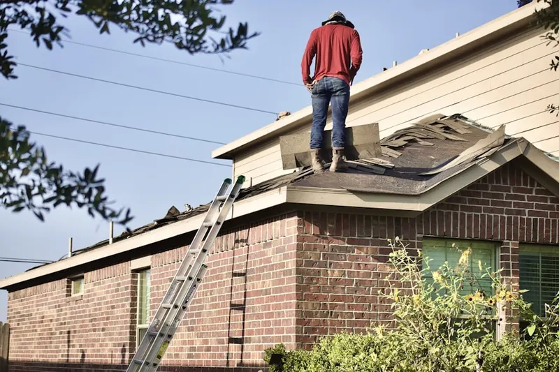Professional roofer working on a residential roof in Estates At Hoffman Farms